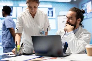 CO 226 Denial Code review with healthcare staff analyzing billing data and claim details on laptop