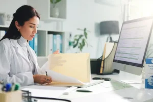A healthcare billing professional reviews patient files and claim information, showcasing the accuracy and efficiency provided by a reliable medical billing company in California.